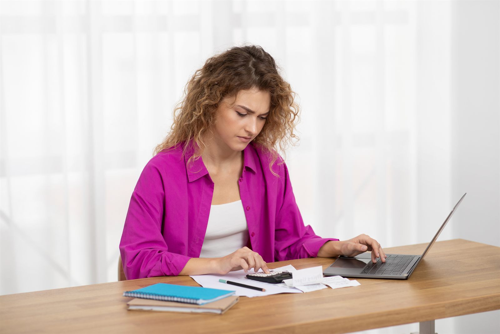 Profissional fazendo contas com calculadora e notebook para planejar o orçamento da clínica